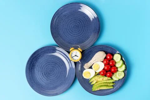 Two empty plates and plate with food on blue background. 스톡 사진