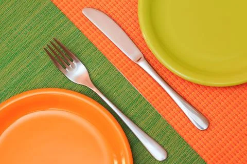 Two empty plates, green and orange Stock Photos