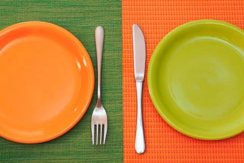 Two empty plates, green and orange Stock Photos