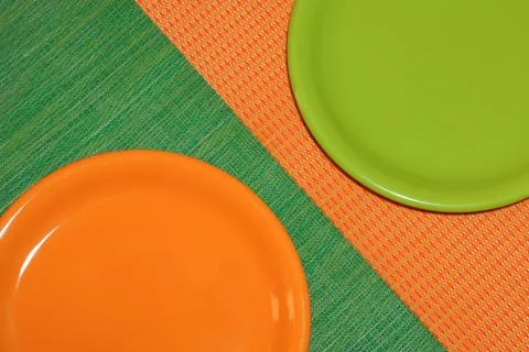 Two empty plates, green and orange Stock Photos