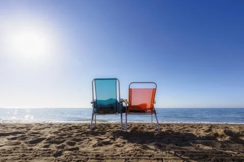 Two empty portable chairs on beach. Stock Photos