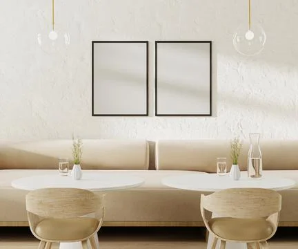 Two empty poster frames above light beige sofa in cafe with round coffee tabl Illustrazione stock