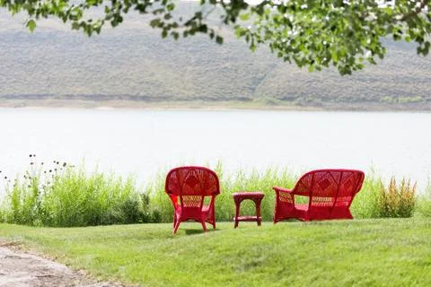 Two empty red seats overlooking lake Stock Photos