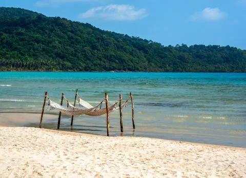 Two empty rope cradle on peace sandy beach and sea on the island and blue s.. Stock Photos