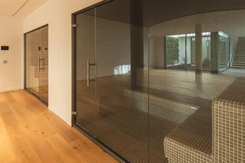 Two empty saunas in a spacious room with a wooden floor and white walls Foto stock