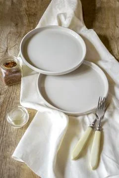 Two empty serving white plates with forks and napkin. Table setting. Foto stock