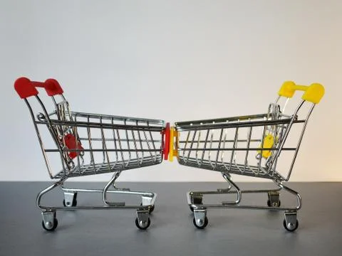 Two empty shopping carts opposite each other on a white-and-gray background. Foto stock