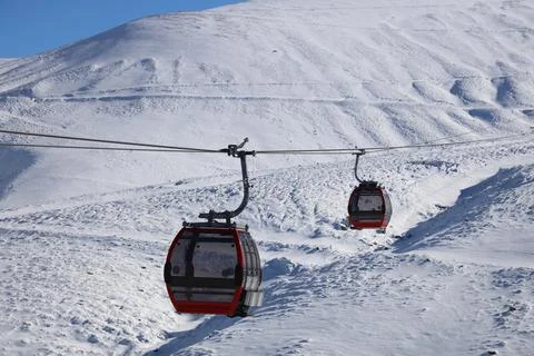 Two empty ski lifts are moving on different directions Stock Photos