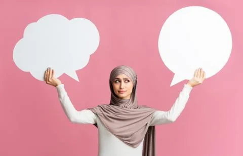 Two empty speech bubbles in hands of concerned muslim woman Stock Photos