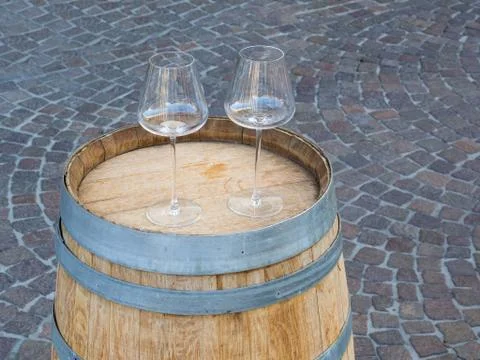Two empty stemware on a  wooden barrel. Paver blocks background Stock Photos