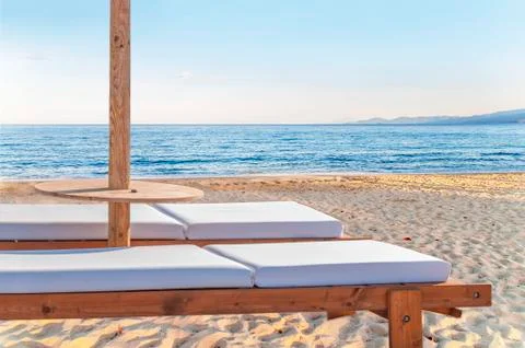Two empty sun bed at big sandy beautiful beach for relaxation Stock Photos