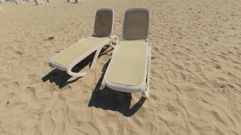 Two Empty Sun Loungers on Sandy Beach Under Bright Summer Sun Stock Footage 346690324