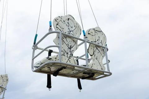 Two Empty Swing Seats Suspended High Above the Ground Against a Cloudy Sky Stock Photos
