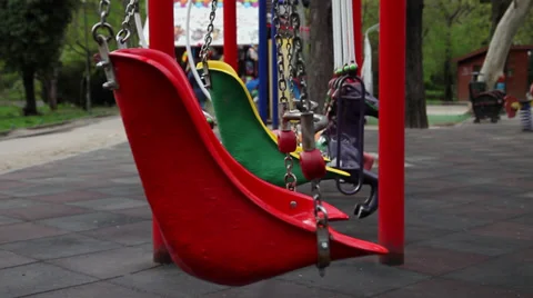 Two empty swings moving on the playground, park, spring season Stock Footage 37124391