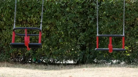 Two empty swings, one swinging, one still Stock-Footage 12300430