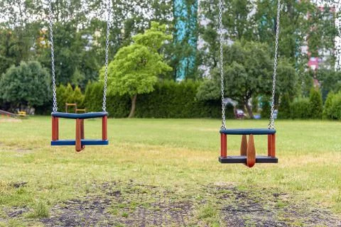 Two empty swings on the playground Stock Photos