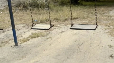Two empty swings swinging Stock Footage 58726453