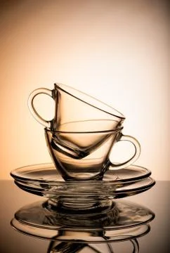 Two empty transparent coffee cup isolated on orange background. Stock Photos