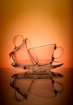 Two empty transparent coffee cup isolated on orange background. Stock Photos