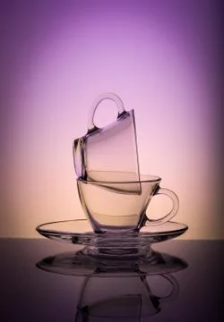Two empty transparent coffee cup isolated on purple background. Stock Photos
