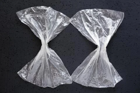 Two empty transparent plastic bag on a dark background. Stock Photos