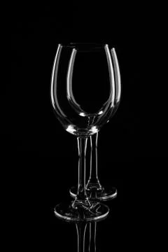 Two empty transparent wine glasses, isolated on black background Stock Photos