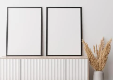 Two empty vertical picture frames standing on wooden sideboard. Mock up inter Foto stock