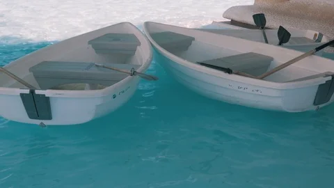 Two empty white boats swing in the clear water. Stock Footage 104612672