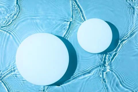 Two empty white circle podium on transparent blue water background Stock Photos