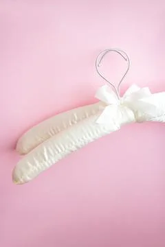 Two empty white clothes hangers on a bright pink background with copy space Stock Photos