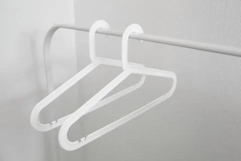 Two empty white plastic clothes hangers Stock Photos