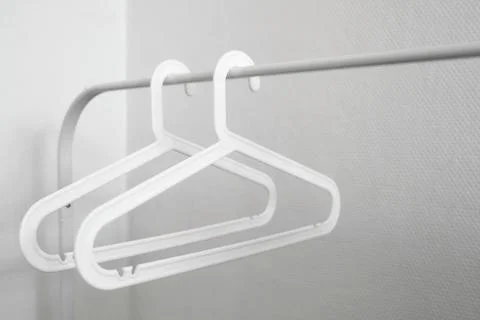 Two empty white plastic clothes hangers Foto stock