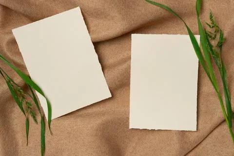 Two empty white sheets with grass on a fabric background from above. Copy spa Stock Photos