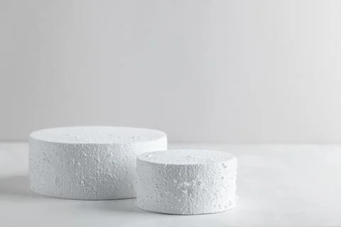Two empty white snowy textured podiums on clean winter background for minim.. Fotos Stock