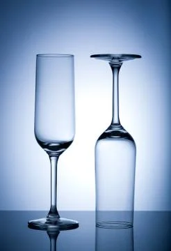 Two Empty wine glasses isolated on blue background. Stock Photos