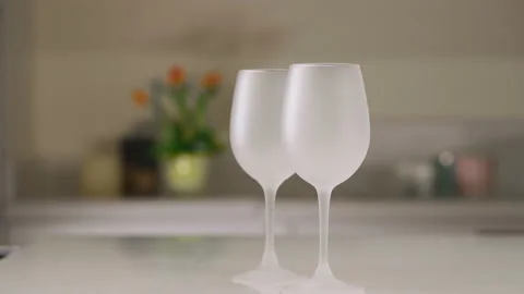 Two empty wine glasses in the kitchen. White wine glasses. Smooth movement of 库存影片 173548282