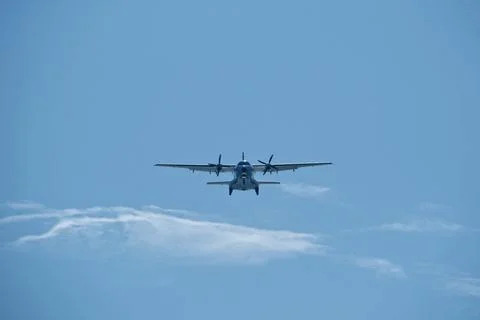 Two-engine airplane in the blue sky. Turboprop transport aircraft Stock Photos