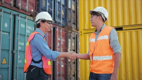 Two engineer handshaking with the cargo background to agree Stock Footage 166992178