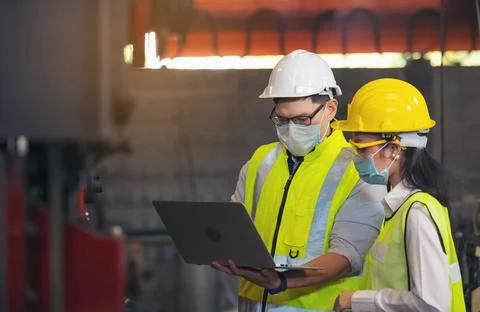 Two engineer in hard hat wearing safety using laptop for planning a project.  Stock Photos