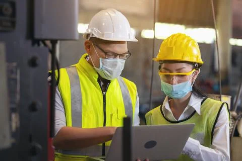 Two engineer in hard hat wearing safety using laptop for planning a project.  Stock Photos