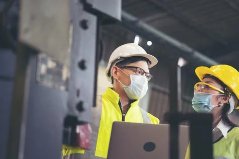 Two engineer in hard hat wearing safety using laptop for planning a project.  Stock Photos