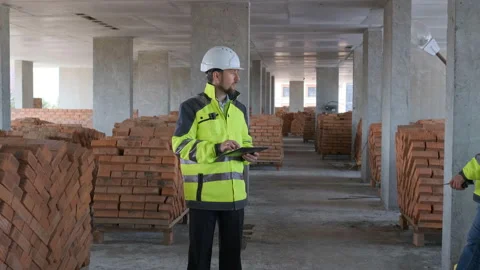 Two Engineer In Helmets With Tablet Device And Big Paper Drawings Discussing Stock Footage 113121566