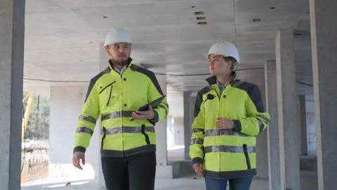 Two Engineer In Helmets With Tablet Device And Big Paper Drawings Discussing Stock Footage 113348638
