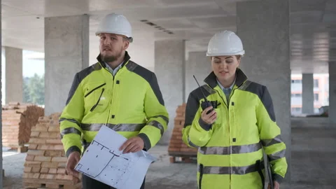 Two Engineer In Helmets With Tablet Device And Big Paper Drawings Discussing Stock Footage 113352407