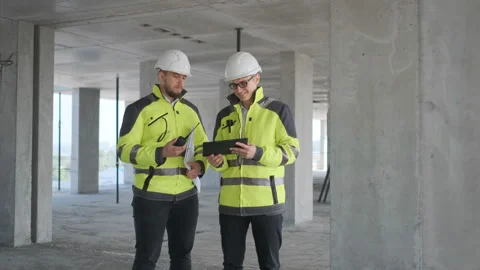 Two Engineer In Helmets With Tablet Device And Big Paper Drawings Discussing Stock Footage 113353110