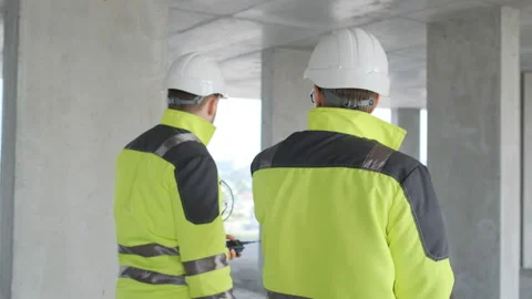 Two Engineer In Helmets With Tablet Device And Big Paper Drawings Discussing Stock Footage 113353413