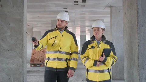 Two Engineer In Helmets With Tablet Device And Big Paper Drawings Discussing Video stock 114533102