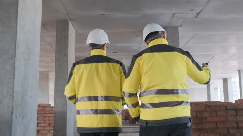 Two Engineer In Helmets With Tablet Device And Big Paper Drawings Discussing Video stock 114540792