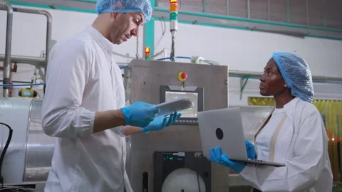 Two engineer inspect heavy machine in juice bottling factory using laptop a.. Stock Footage 343269861