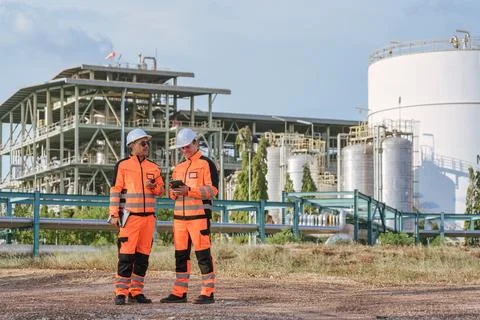 Two engineer in orange uniform discussing and working collaboration at chem.. Stock Photos